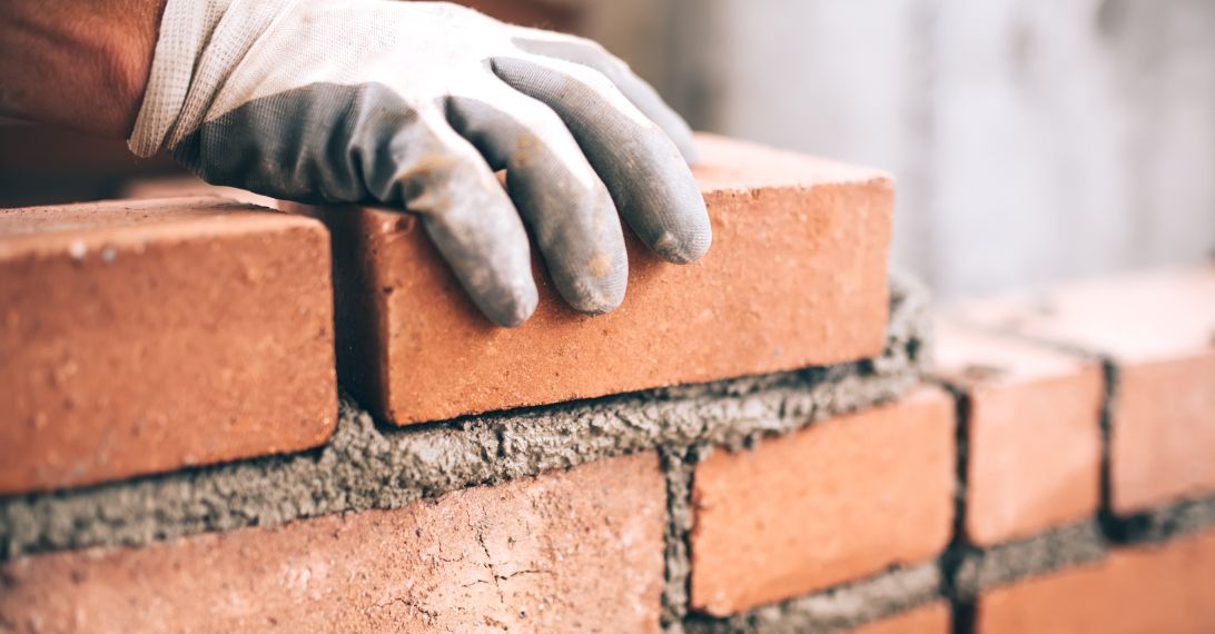 Klinkerarbeiten in Lage, NRW: Handwerker verlegt Backsteine an Hauswand